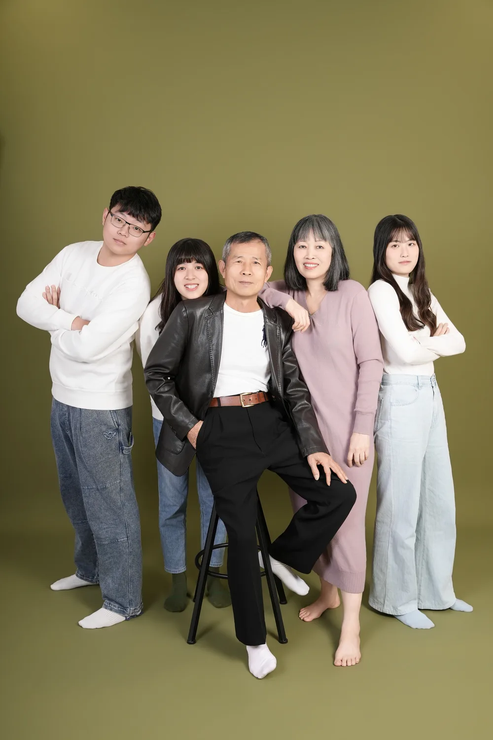 綠色背景直幅五人全家福,以站姿與坐姿錯落呈現全身構圖